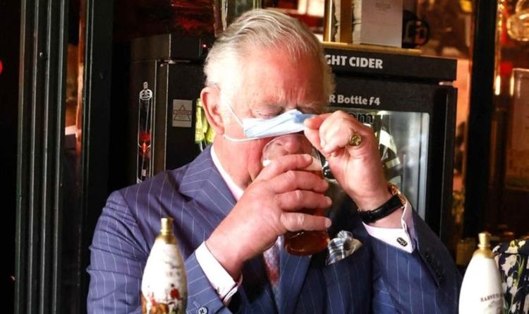 Le bas est en haut!  Le prince Charles lève son masque pour une gorgée de bière effrontée au pub de Clapham