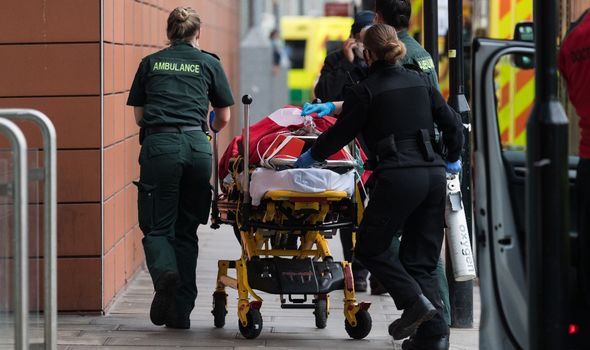 Les ambulanciers transportent un patient de l'ambulance au service des urgences du Royal London Hospital