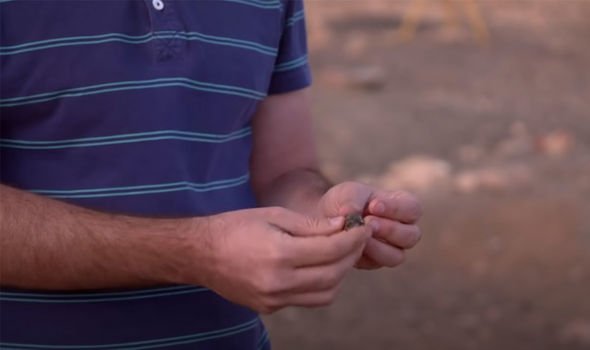 Histoire ancienne : l'un des chercheurs du site tient un morceau de roche travaillée
