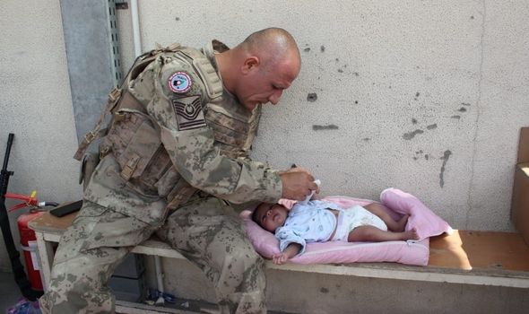Un soldat turc s'occupe d'un bébé 