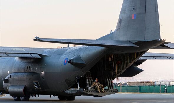 L'équipage est assis sur le hayon du C-130 à destination du Soudan
