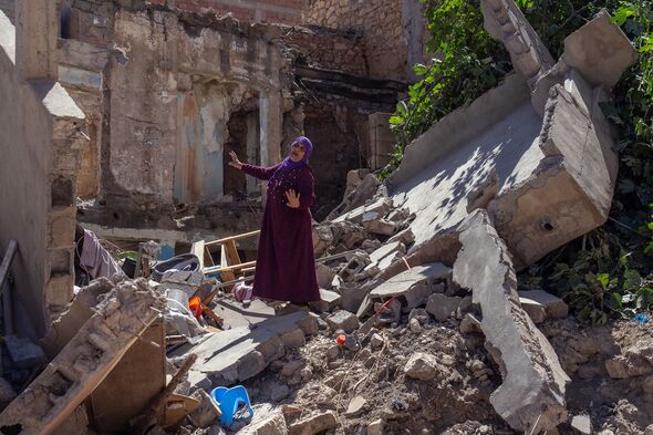 Une femme parmi les décombres de sa maison 