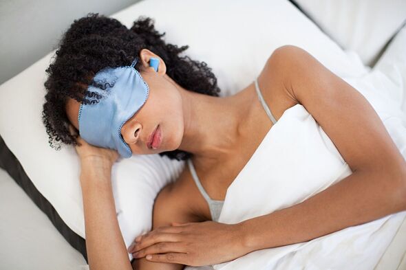 Une femme dort avec un masque et des bouchons d'oreille