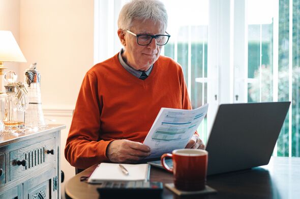 Homme âgé inquiet vérifiant les factures à la maison