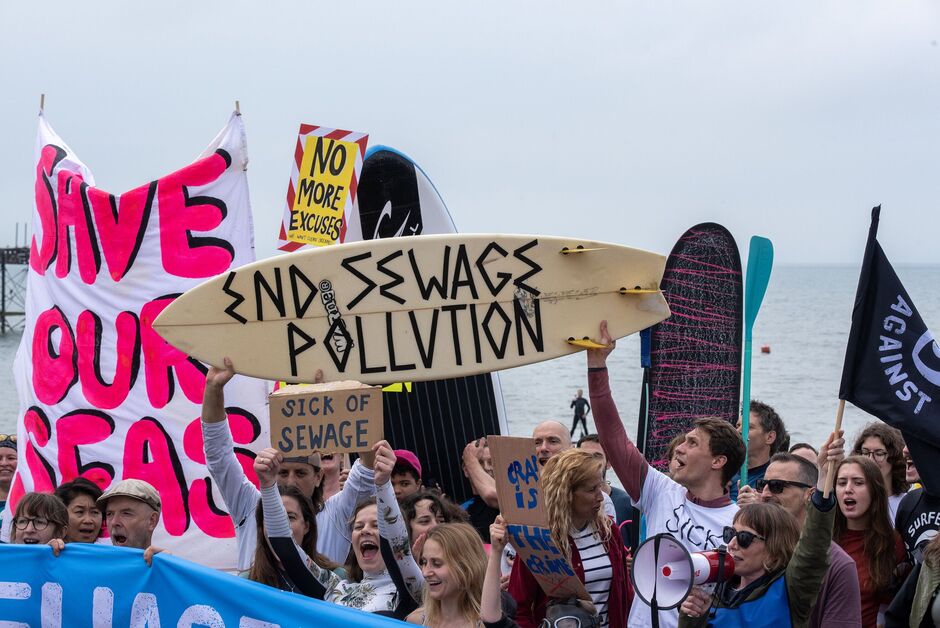 Des manifestants brandissant des pancartes et une banderole crient des slogans...