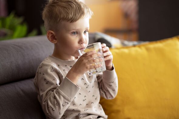 Un jeune garçon avec une boisson dans un verre