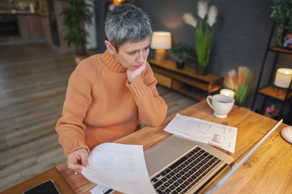 Femme mature inquiète aux cheveux gris courts qui travaille