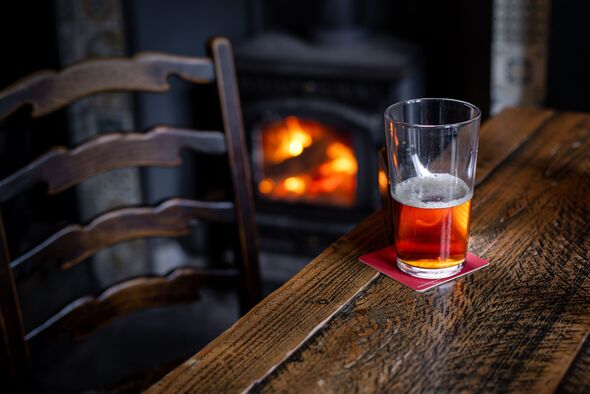 Une demi-pinte de bière pleine sur une table en bois