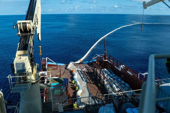 Un navire Ocean Cleanup traînant derrière lui un énorme barrage pour collecter les plastiques du Pacifique