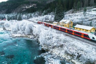 Le magnifique voyage en train européen à travers des forêts et des montagnes enneigées