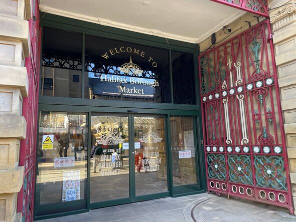 Une image représentant l'entrée principale d'un établissement, caractérisée par des portes en fer forgé rouge et des portes en verre, plomb Une image représentant l'entrée principale d'un établissement, caractérisée par des portes en fer forgé rouge et des portes en verre, plomb