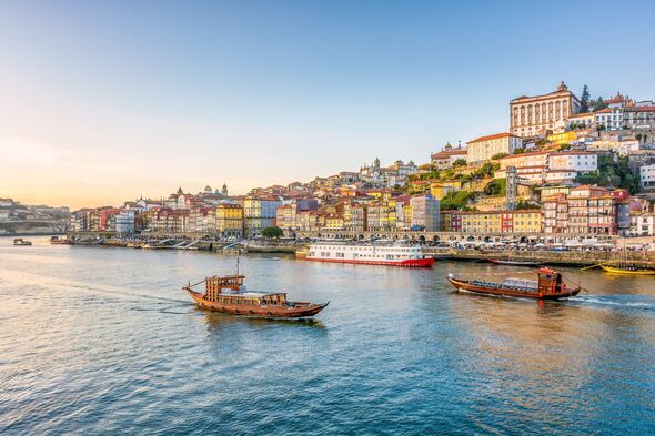 Vue panoramique de la ville de Porto au Portugal dans la lumière chaude du coucher du soleil d'hiver avec des bateaux et le fleuve Douro en premier plan