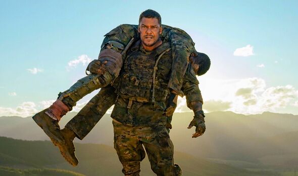Alan Ritchson portant un soldat dans War Machine
