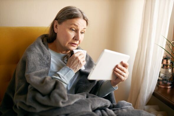 Femme âgée malheureuse éternuant dans un mouchoir