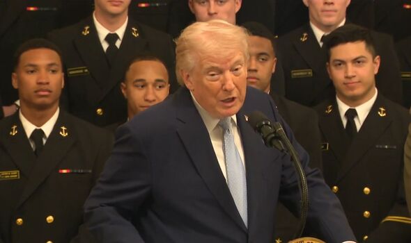 Gros plan de Donald Trump s'exprimant sur un podium avec des membres de la marine derrière lui Gros plan de Donald Trump s'exprimant sur un podium avec des membres de la marine derrière lui