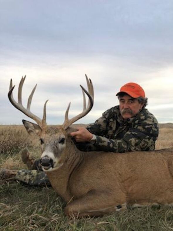 Le chasseur de gros gibier Ernie Dosio pose avec un cerf qu'il a abattu comme trophée