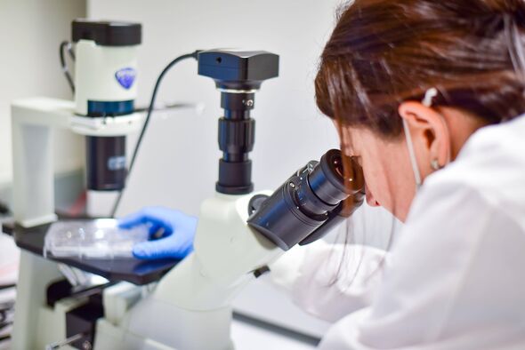 Une femme utilisant un microscope