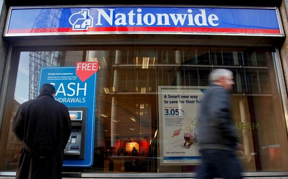 Un client utilise un guichet automatique bancaire (DAB) à l'extérieur d'une succursale de la Nationwide Building Society à Londres