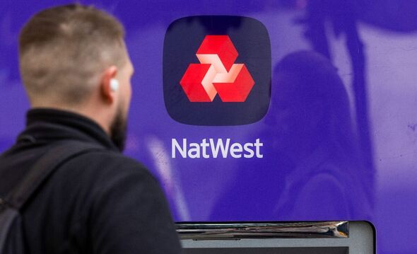Un panneau au-dessus d'un guichet automatique bancaire (ATM) à l'extérieur d'une succursale bancaire de NatWest Group Plc à Londres