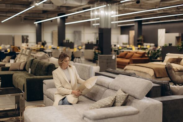 Femme Shopping pour canapés dans un magasin de meubles modernes intérieur Femme Shopping pour canapés dans un magasin de meubles modernes intérieur