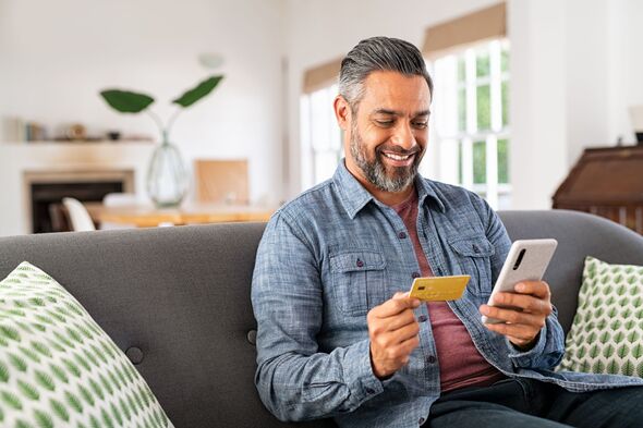 Homme souriant pendant les opérations bancaires en ligne Homme souriant pendant les opérations bancaires en ligne