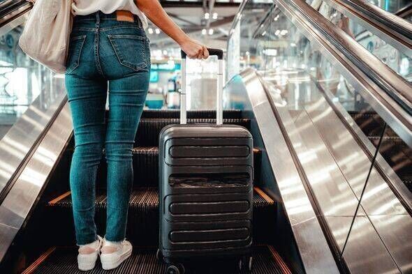 Vue arrière d'une femme voyageant avec une valise